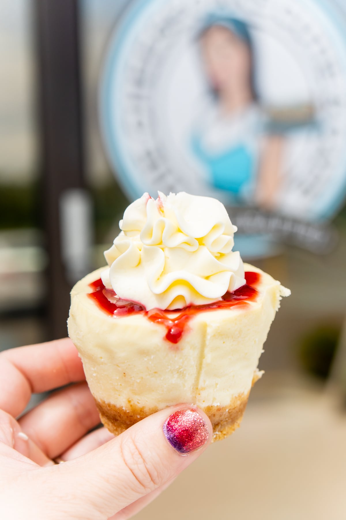 hand holding a cheesecake in front of cheesecake cutie cafe