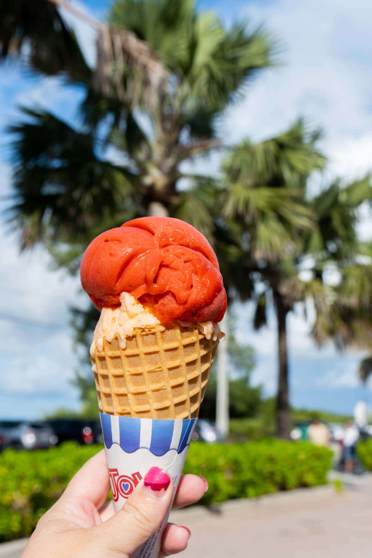 Woman's hand holding a two scoop ice cream cone