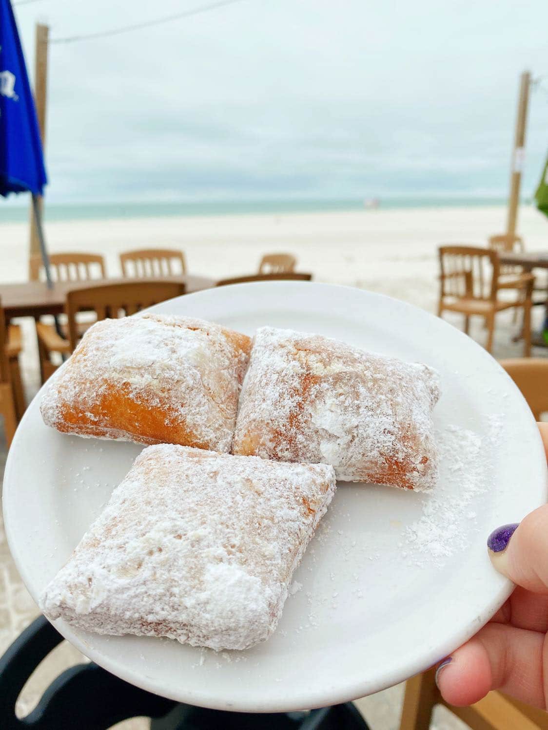 Plate of beignets with beach in the background