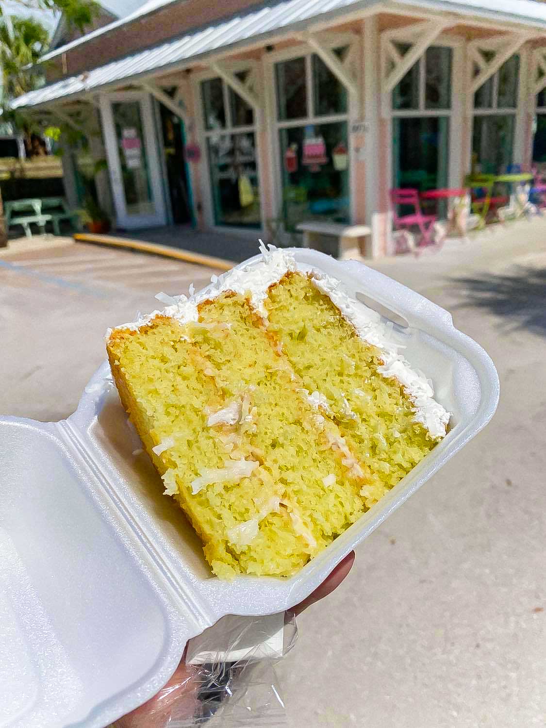 piece of coconut key lime cake in a styrofoam box