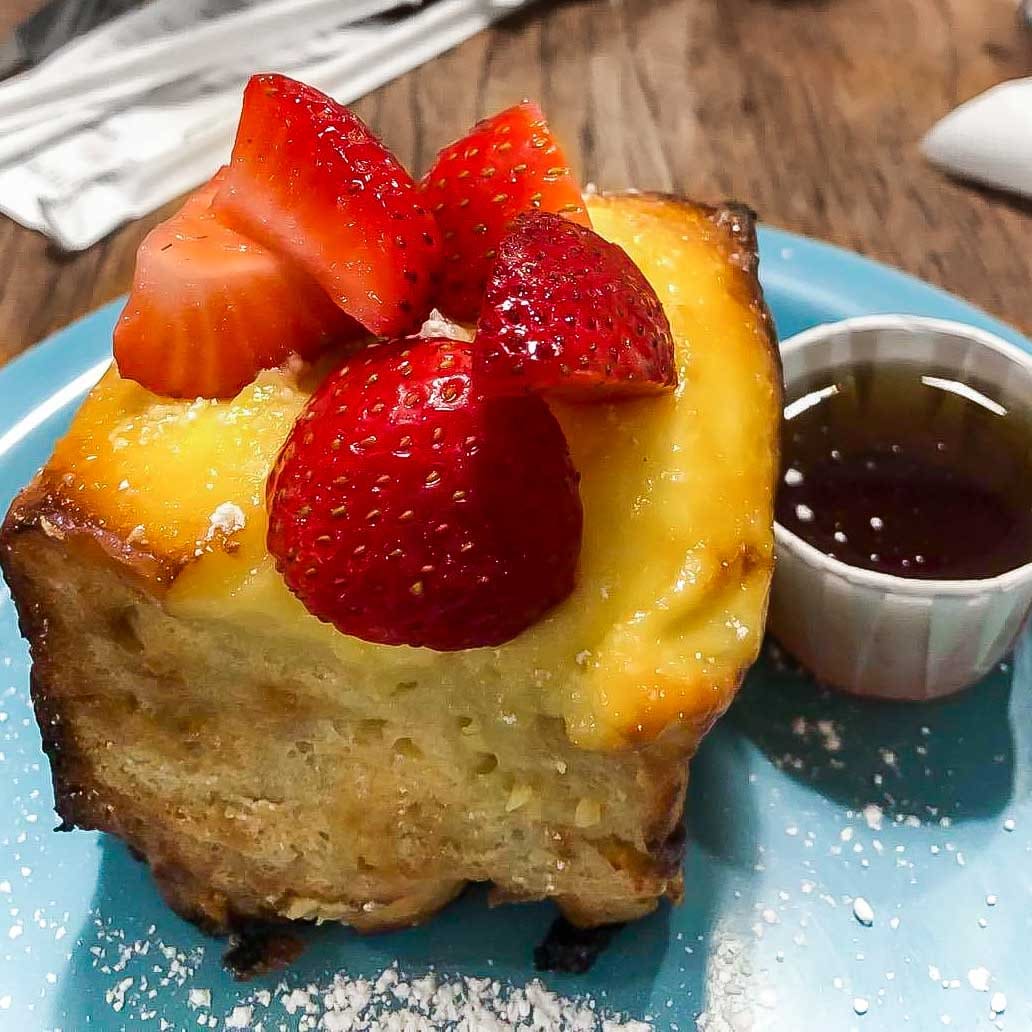 creme brulee French toast with strawberries on a blue plate