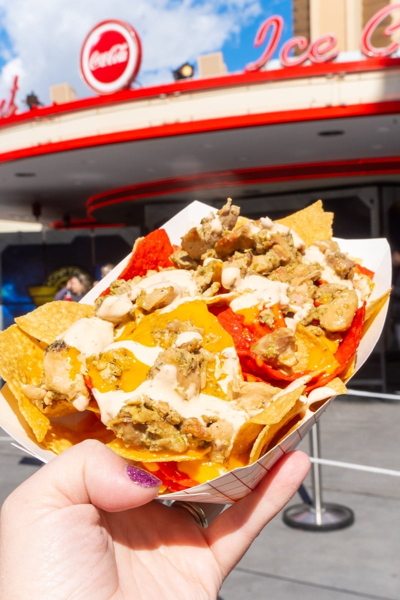 Hand holding a tray of nachos