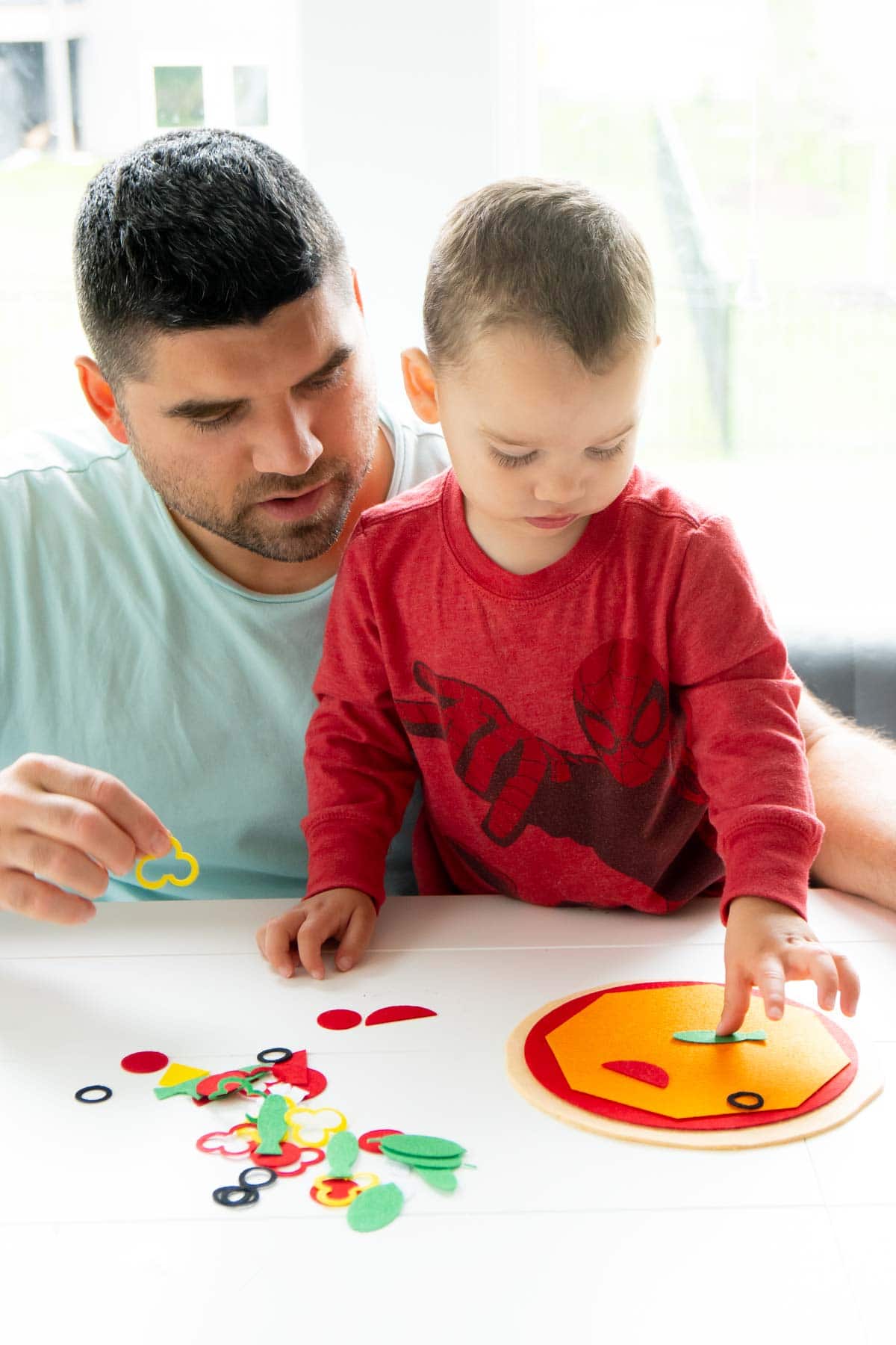 toddler playing with felt pizza set