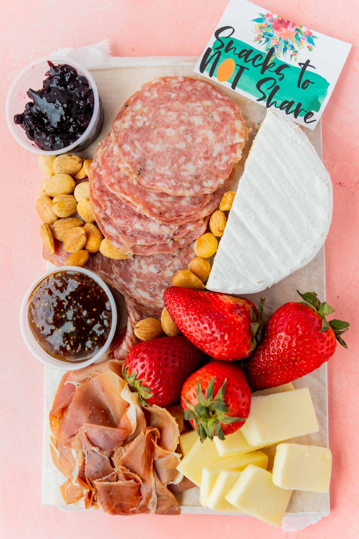 charcuterie board on a pink background