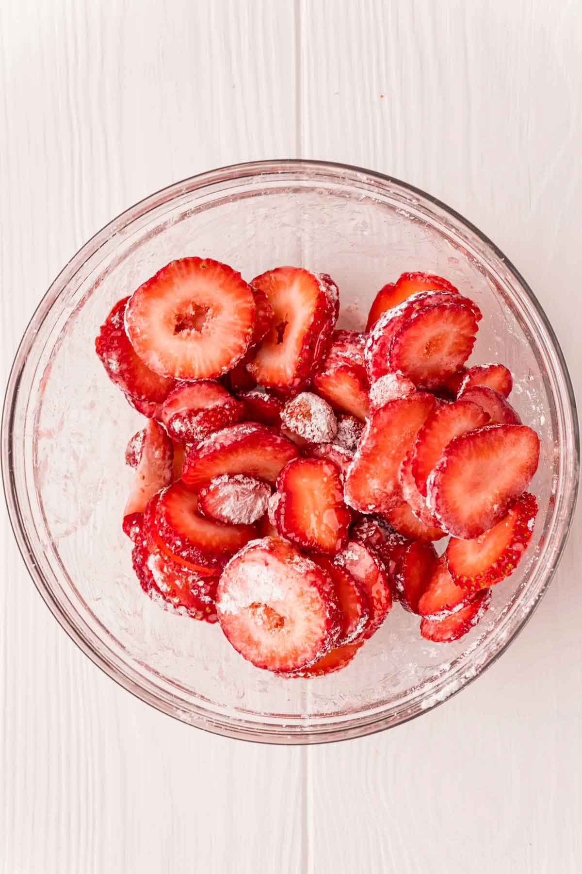 strawberries and sugar in a glass bowl