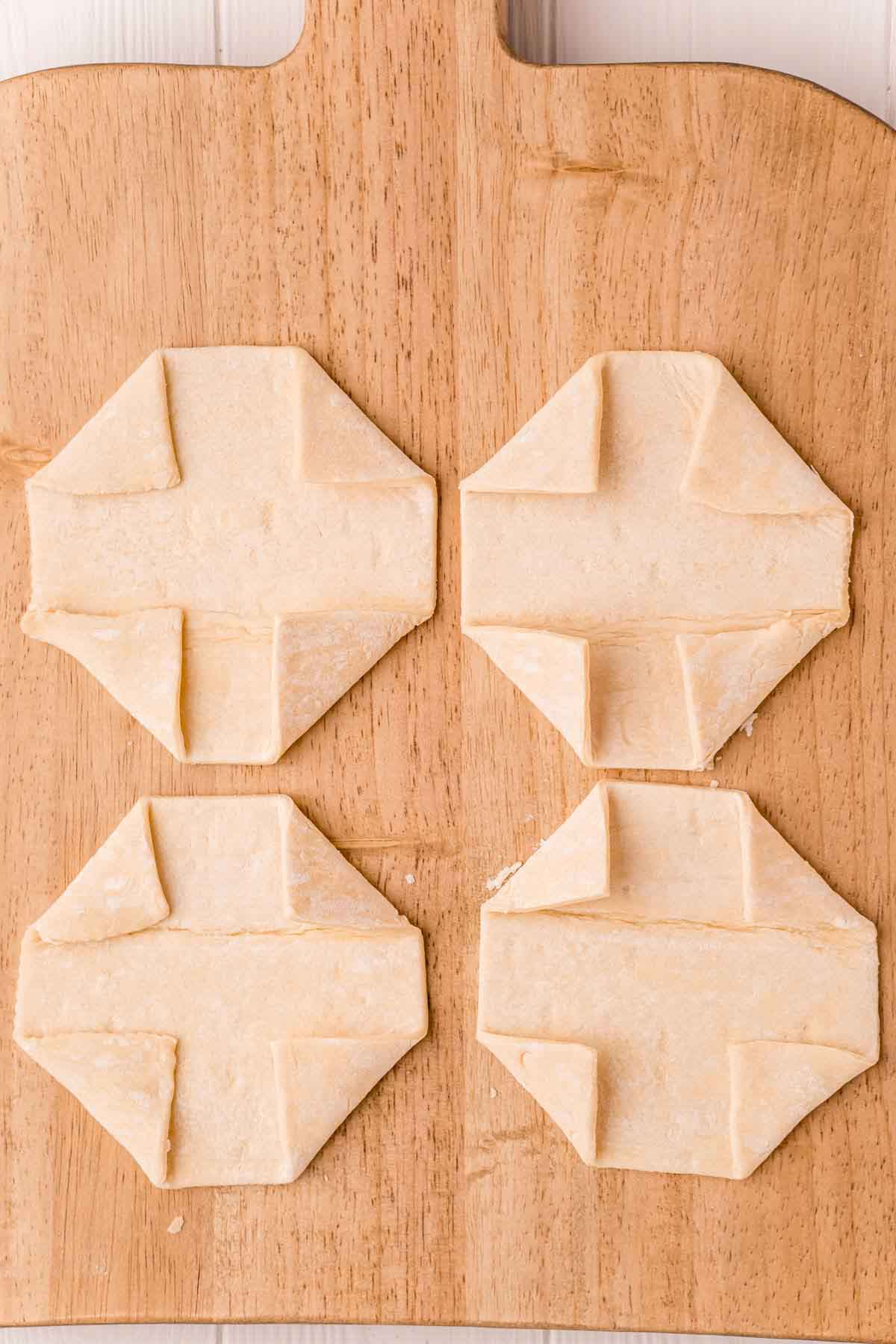 Four puff pastries on a cutting board