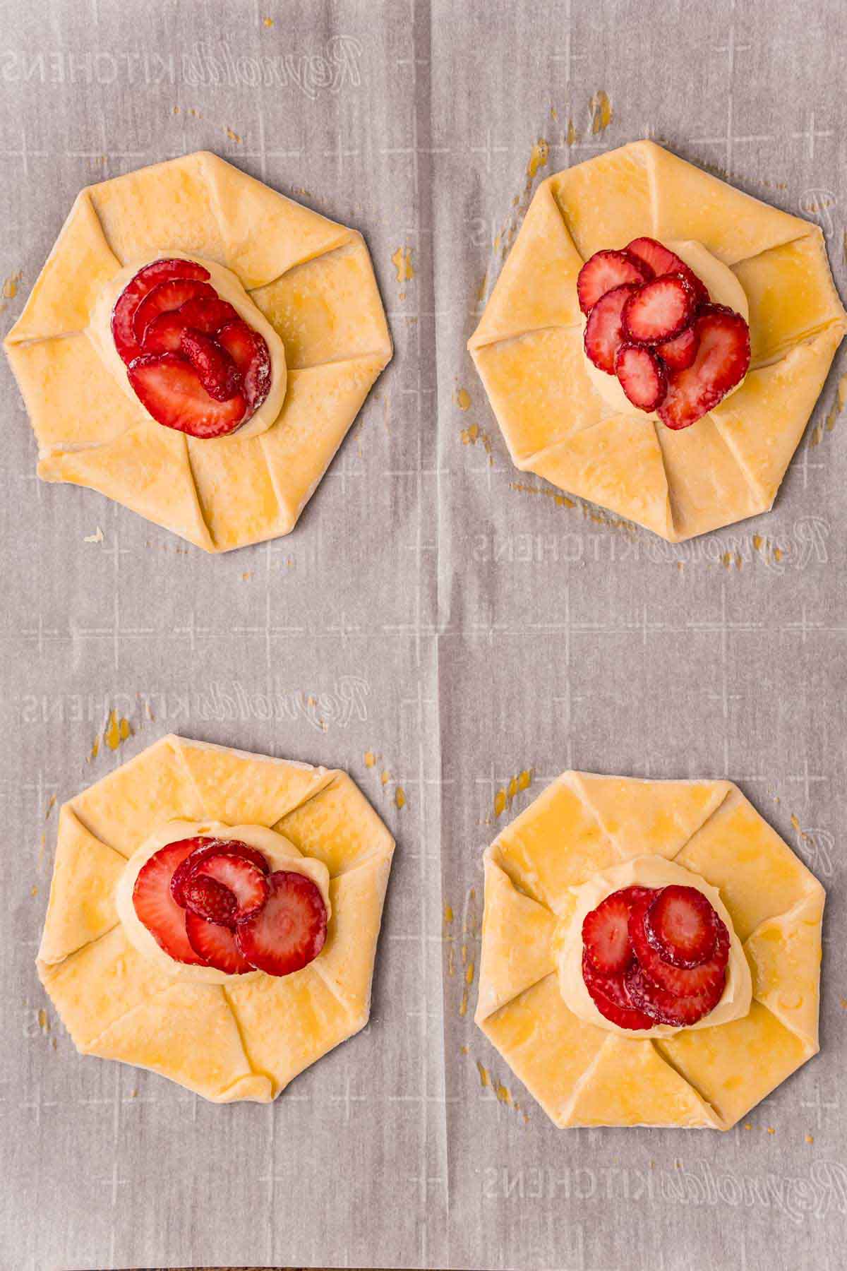 unbaked strawberry danishes on a baking sheet