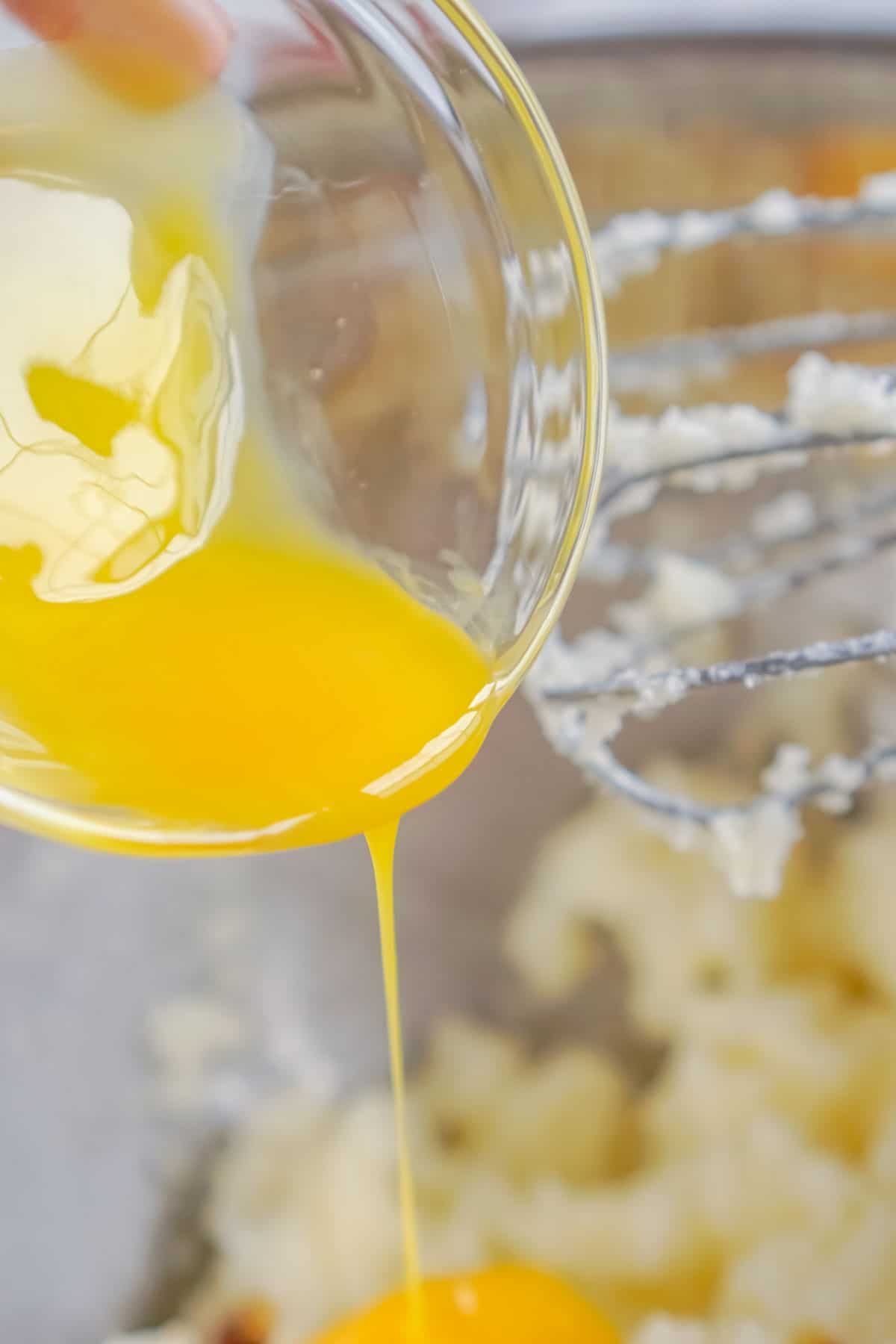 egg in a bowl being poured into a batter