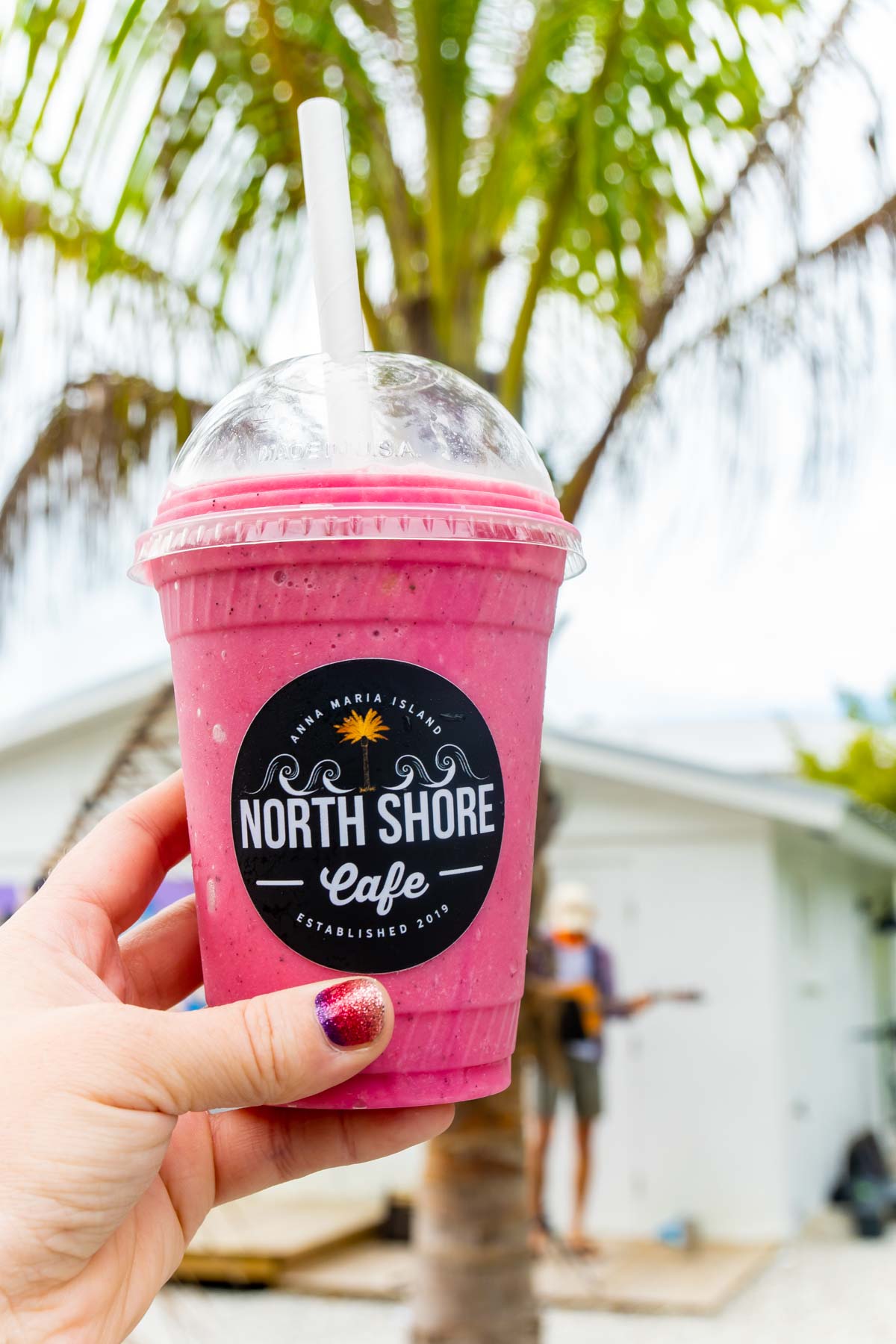 Woman's hand holding a pink smoothie