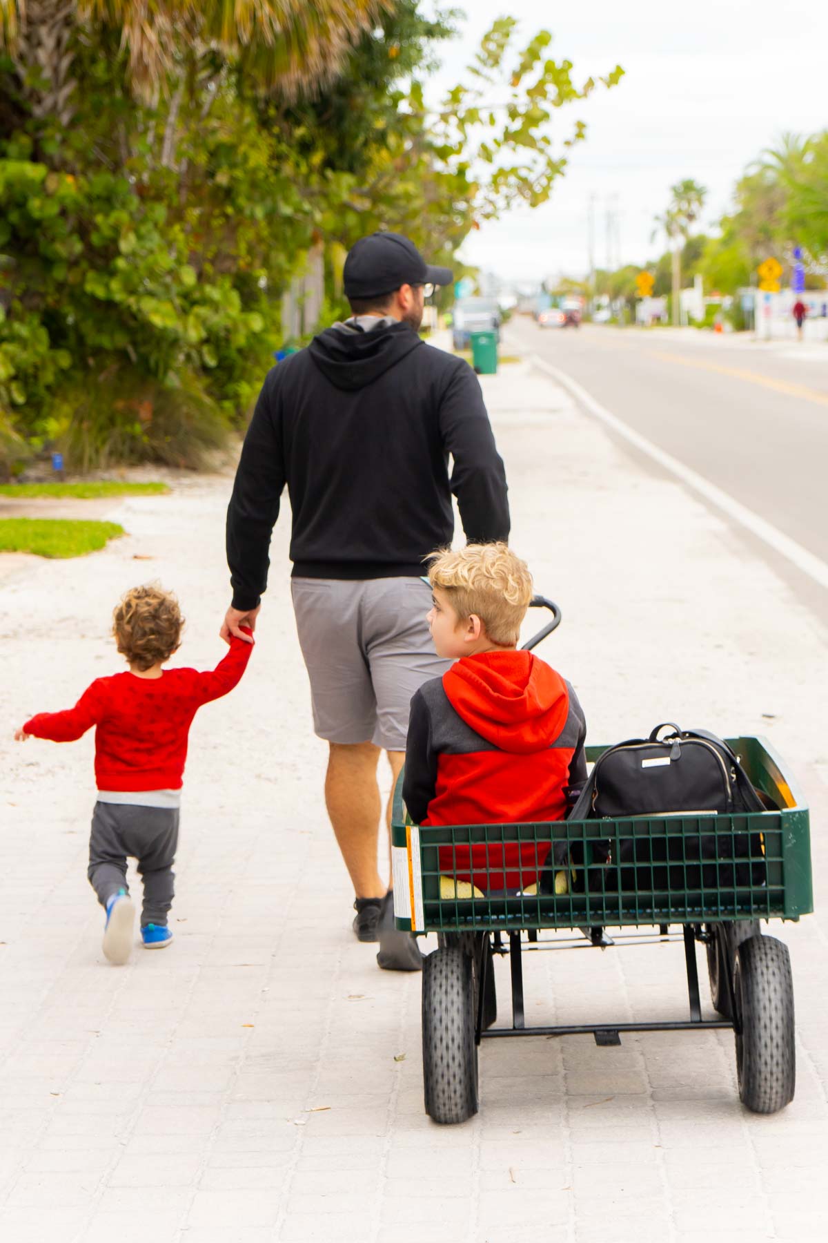 Dad and two boys walking on a street