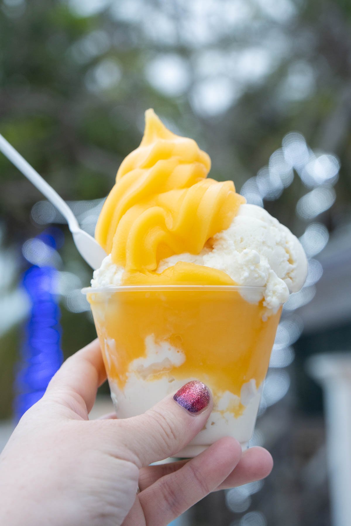 Woman's hand holding mango Italian Ice