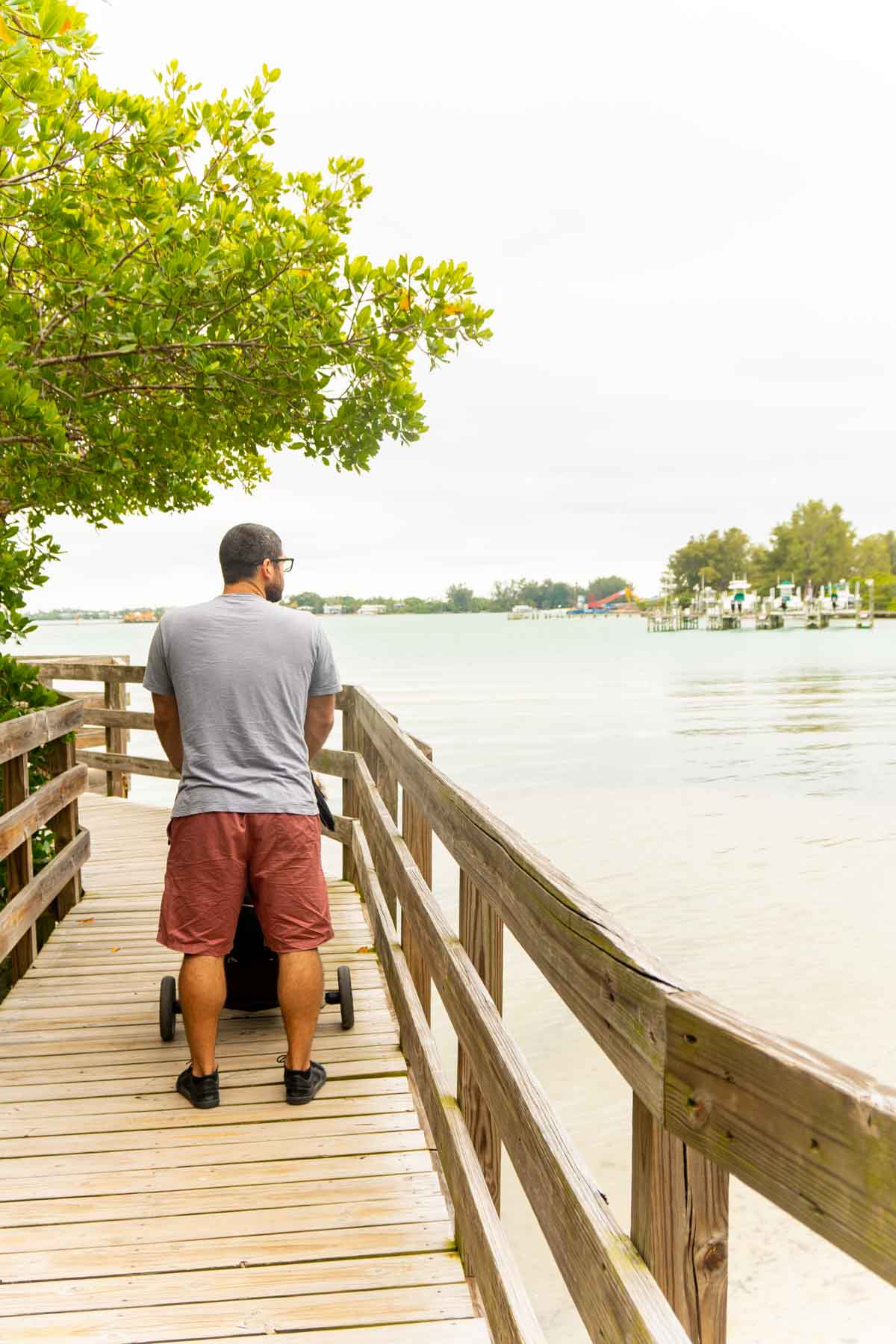 Man pushing a stroller on a wooden bridge