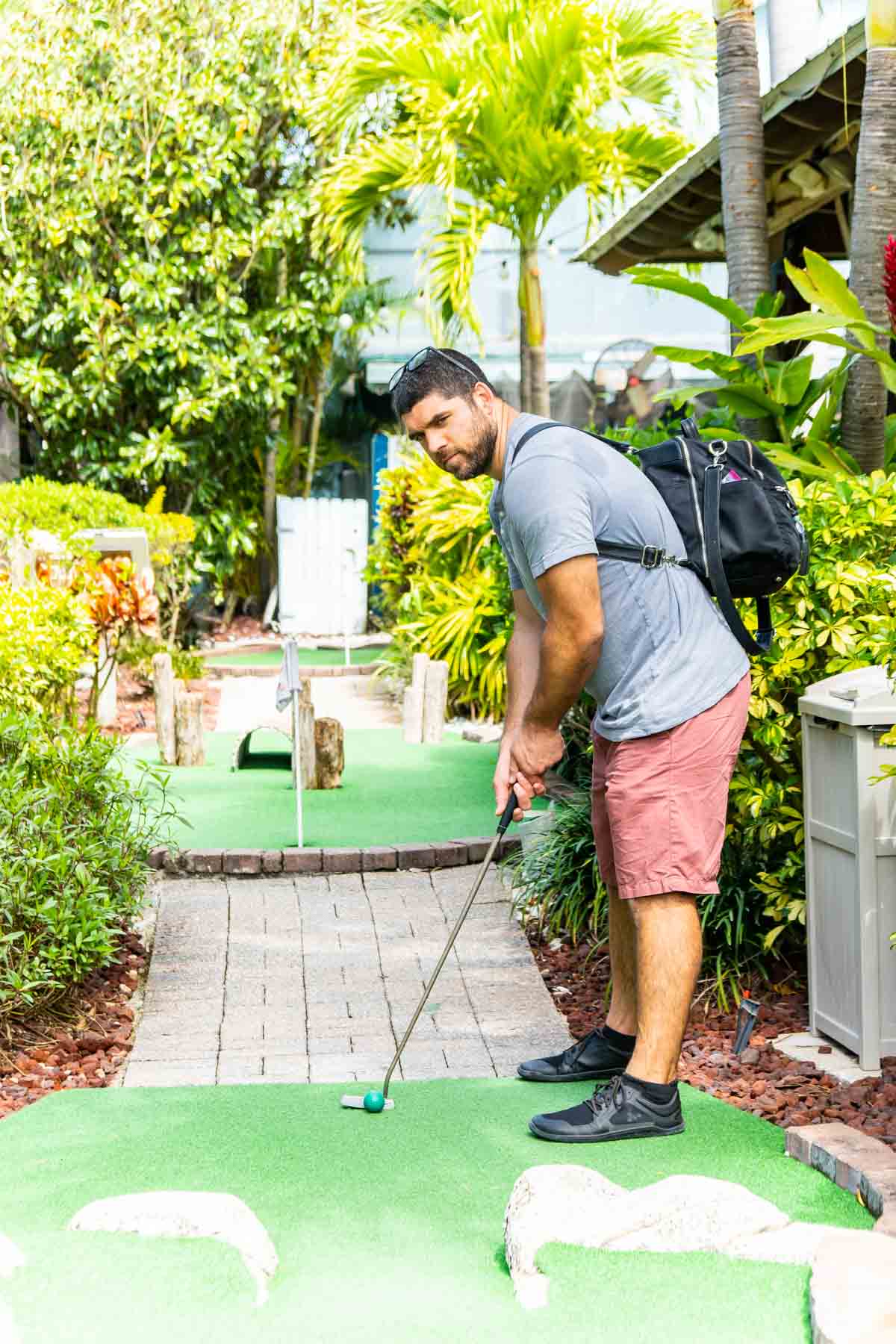 Man playing miniature golf