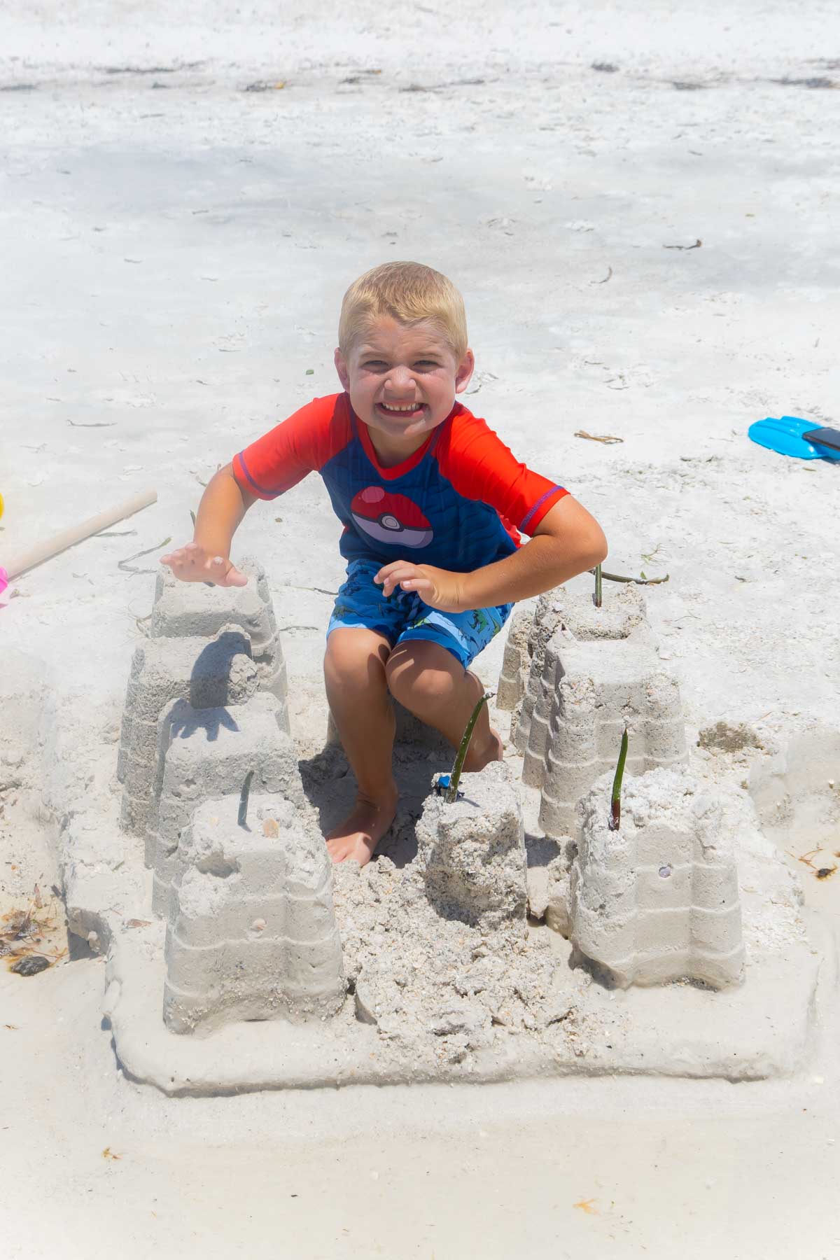 boy with a sand castle on the beach