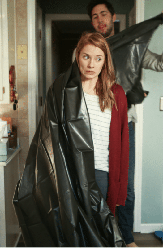 girl putting on a black tablecloth gown