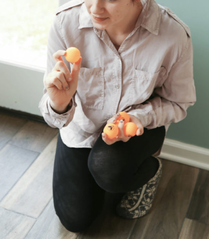 girl holding orange ping pong balls