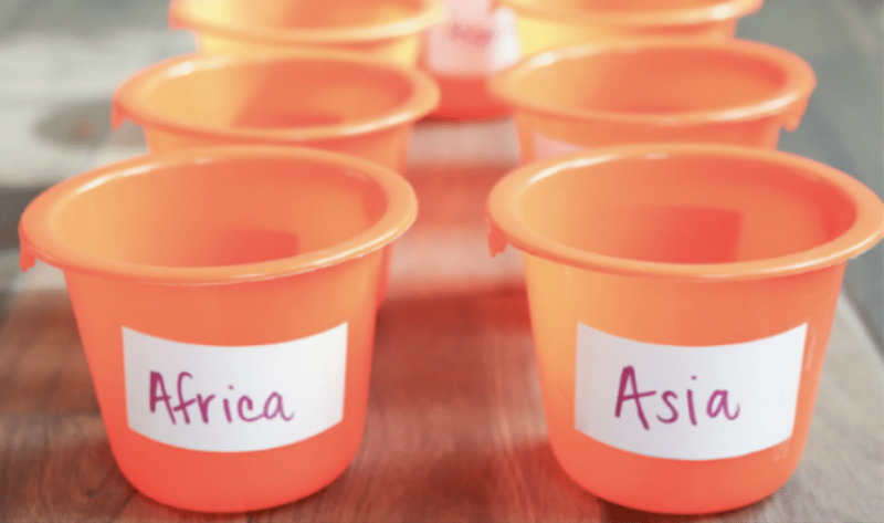 orange buckets with continent labels on them