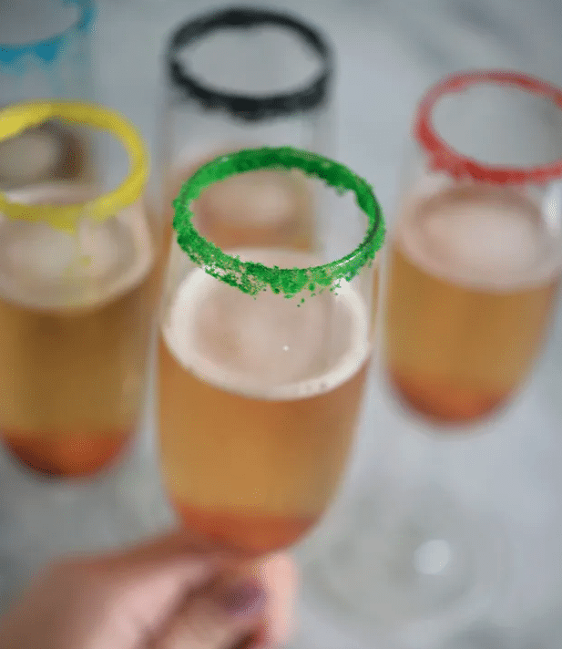 hand holding a champagne flute with rims dipped in sugar
