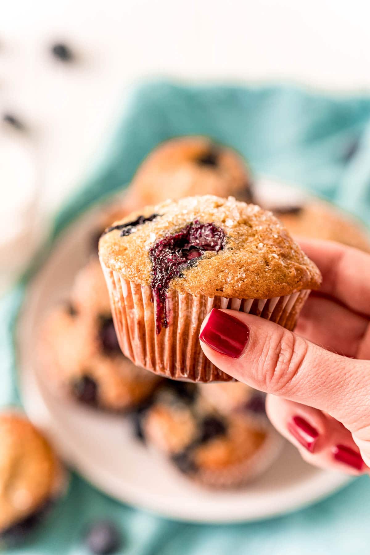 hand holding a juicy blueberry muffin