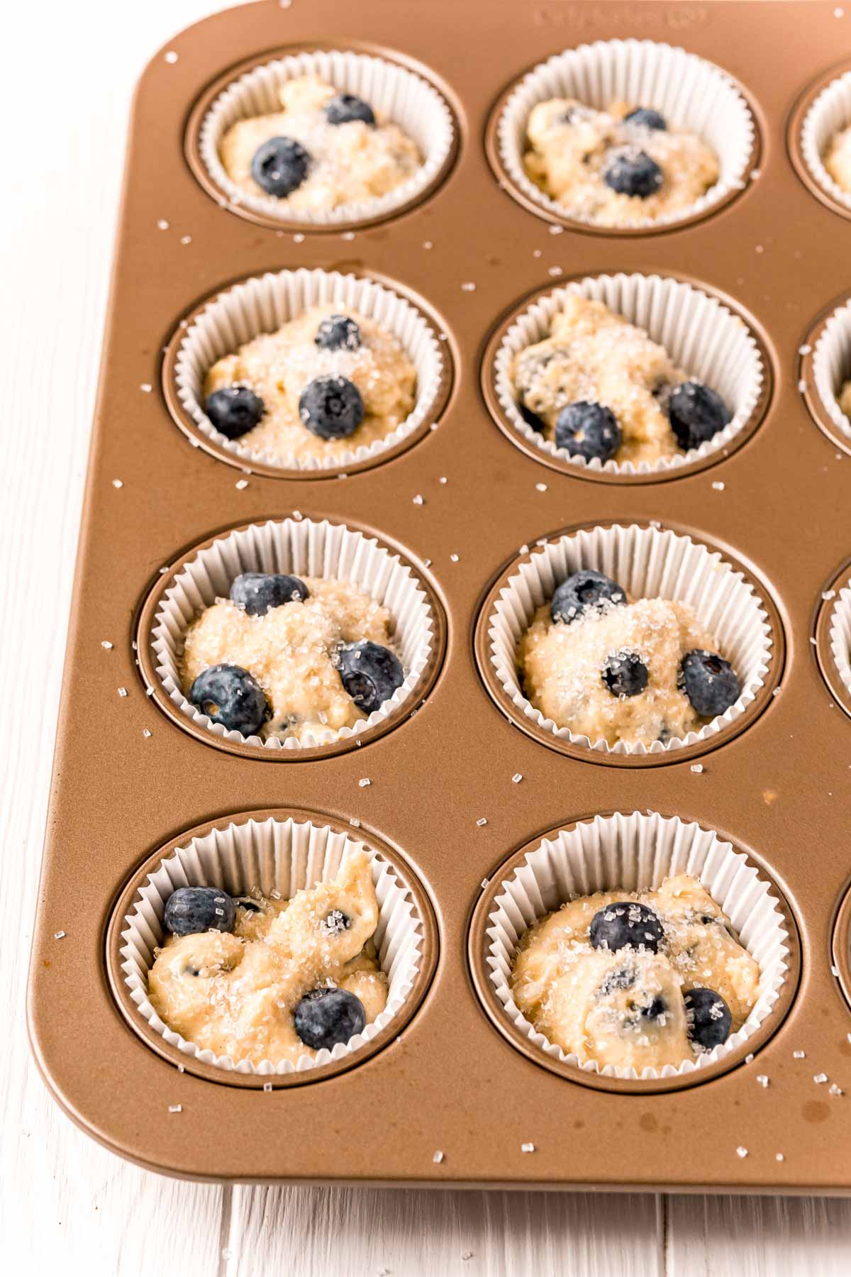muffin tins with blueberry batter
