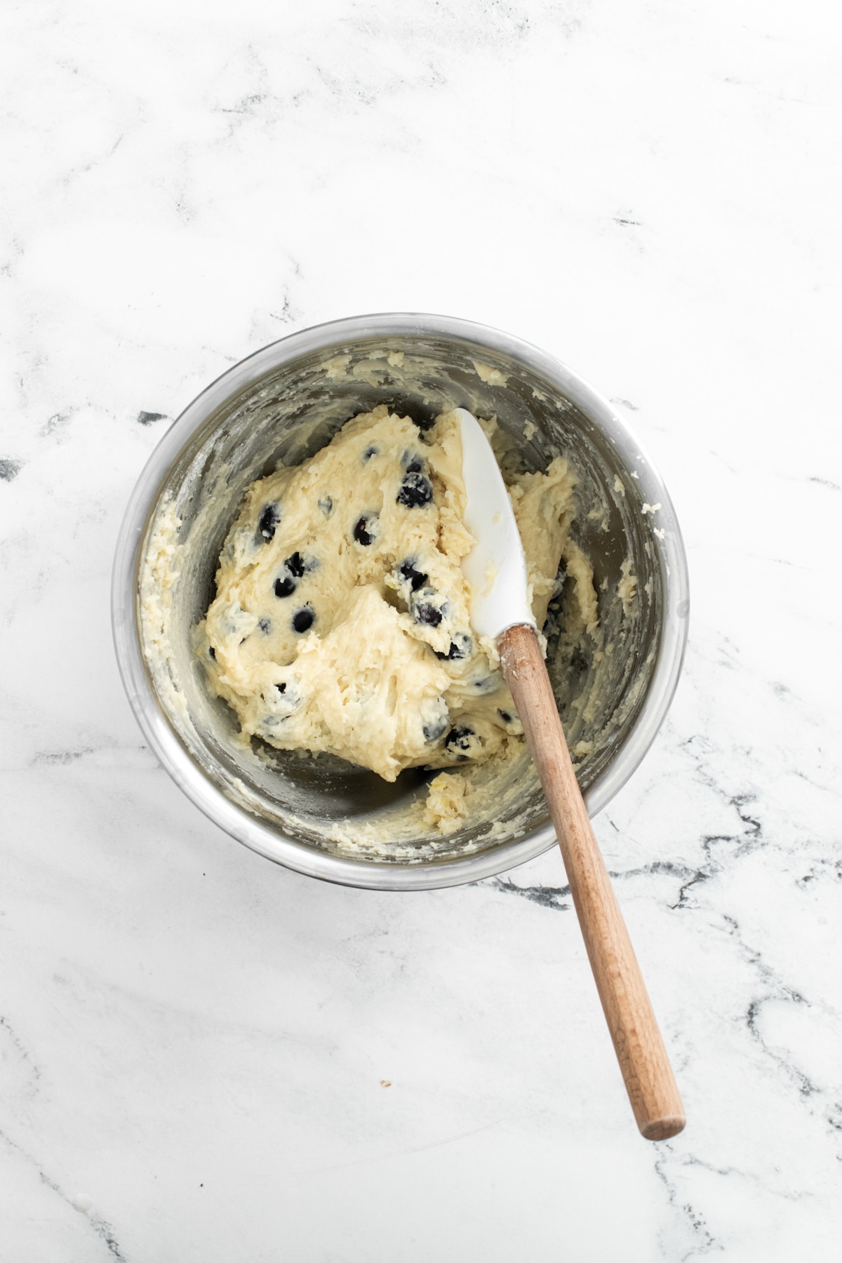 metal bowl with lemon blueberry muffin batter and a spatula