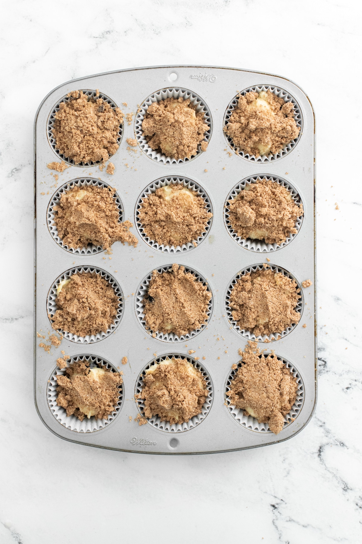 unbaked lemon blueberry muffins with crumb topping