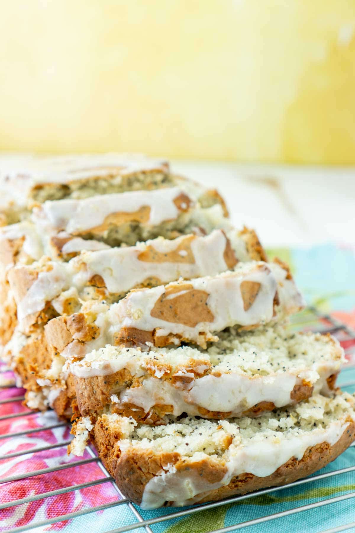 sliced lemon poppy seed bread with a yellow background