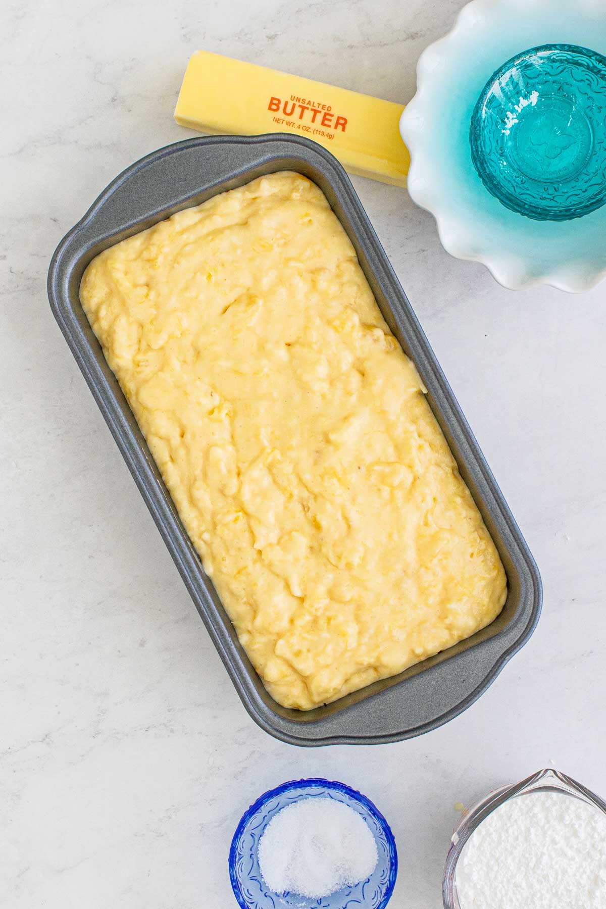 metal loaf pan with pineapple bread batter