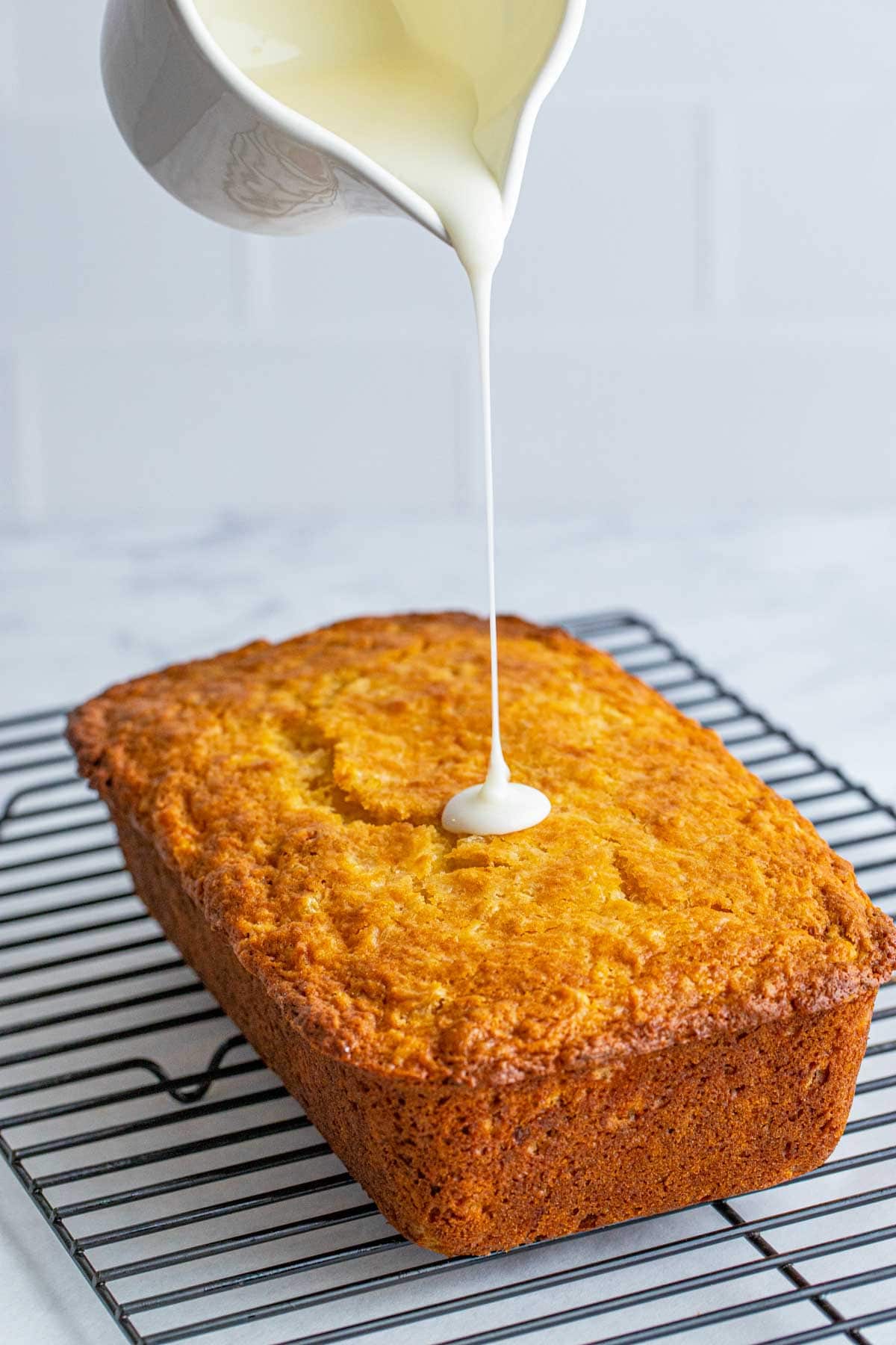 a jar pouring glaze onto pineapple bread