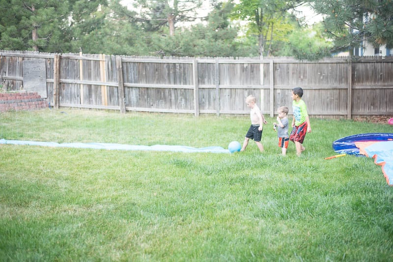 Kids standing at a slip and slide