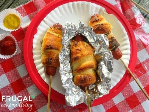Hot dogs on sticks on a paper plate