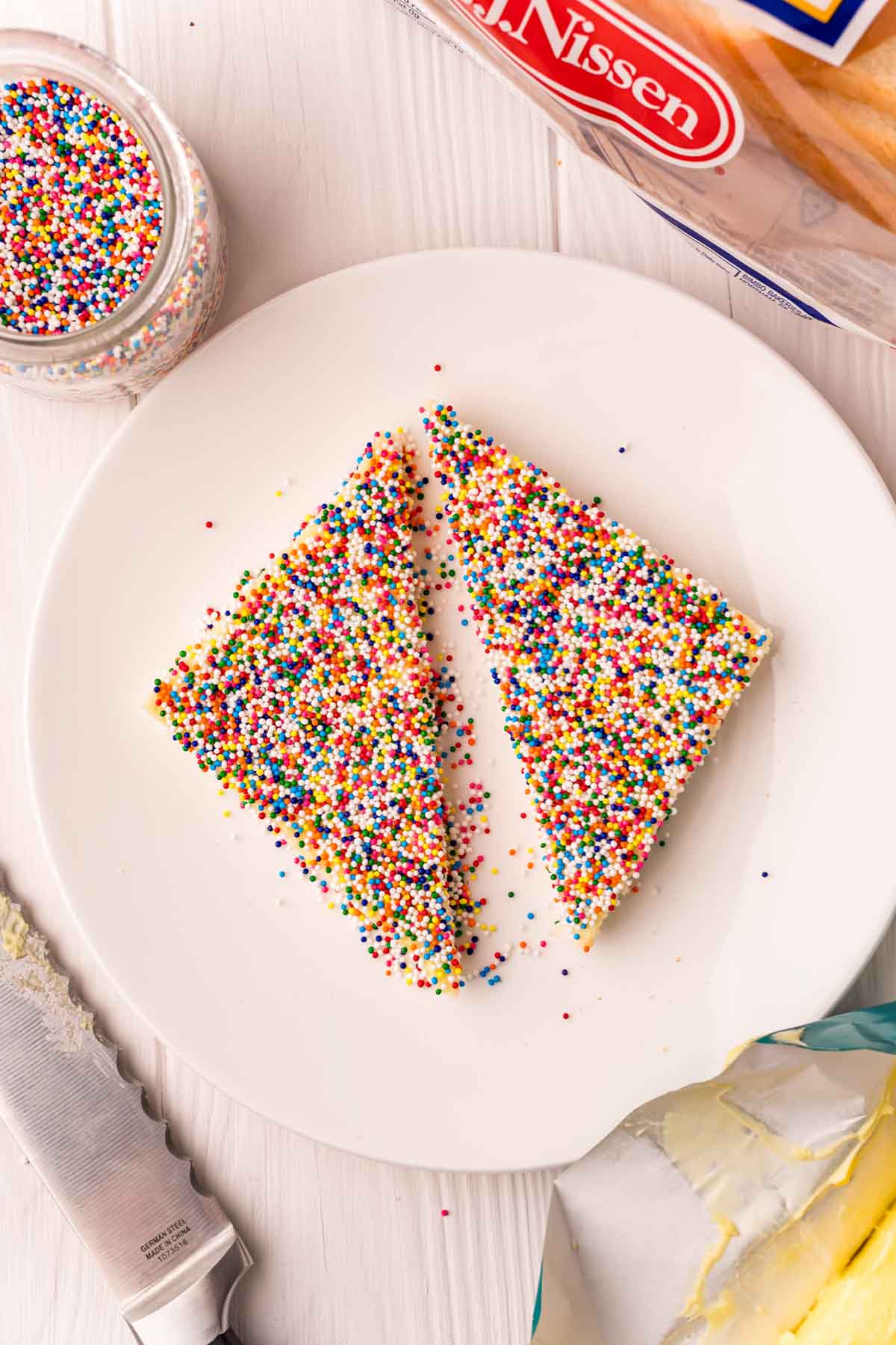 two pieces of fairy bread on a white plate