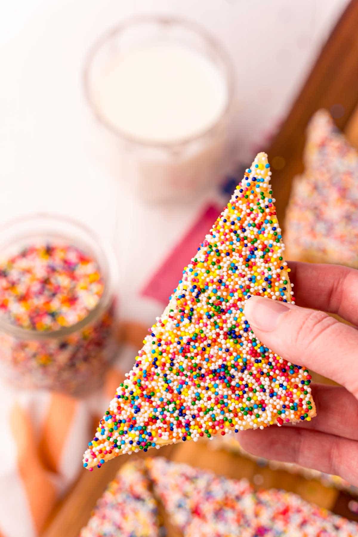 woman's hand holding a piece of fairy bread