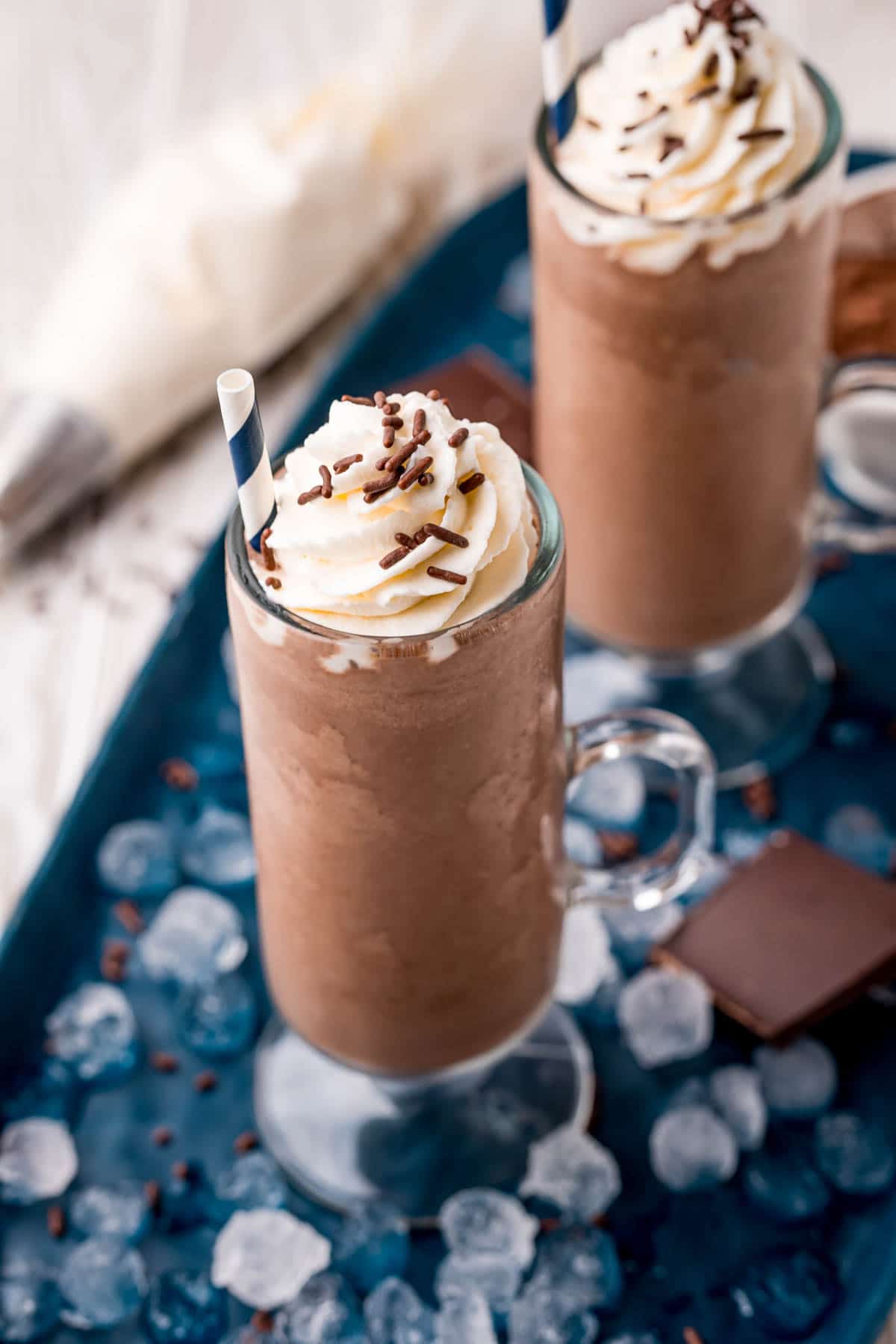 Two glasses of frozen hot chocolate with a blue napkin