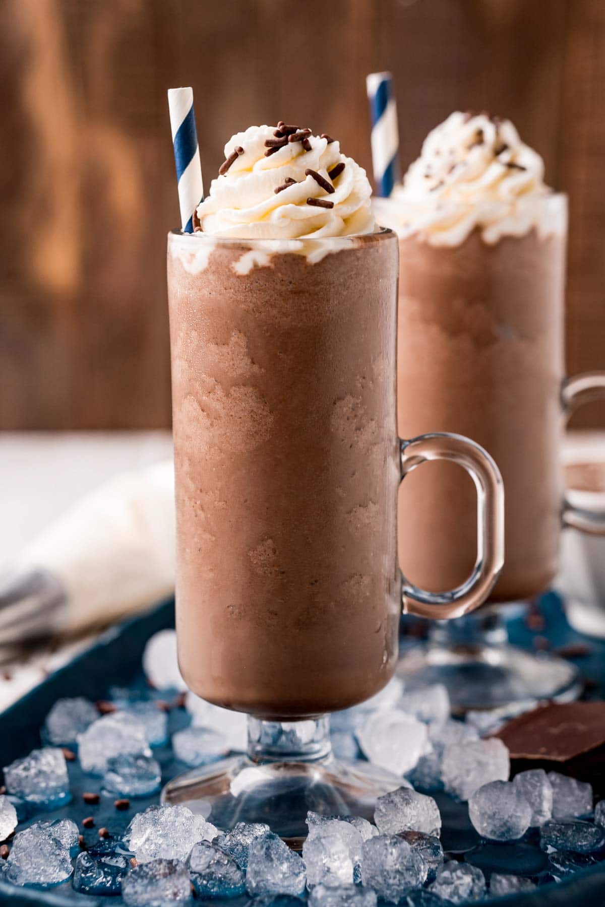 Two glasses of frozen hot chocolate with ice around