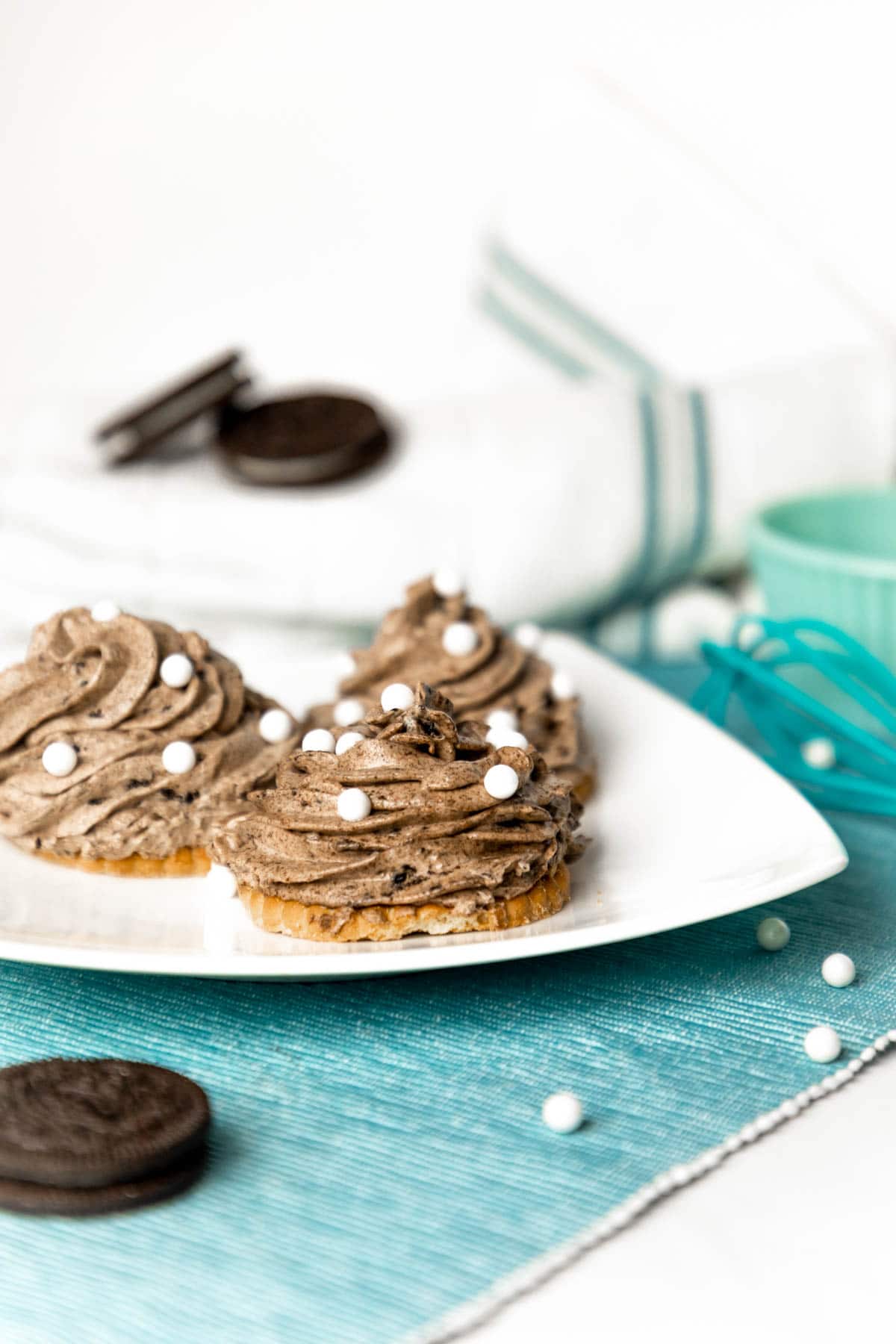 white plate with two grey stuff cookies on them