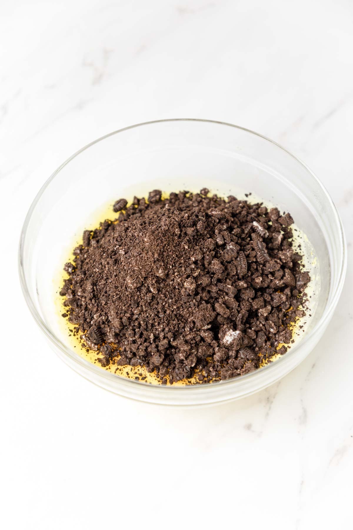 Oreo crumbs on top of vanilla pudding in a bowl