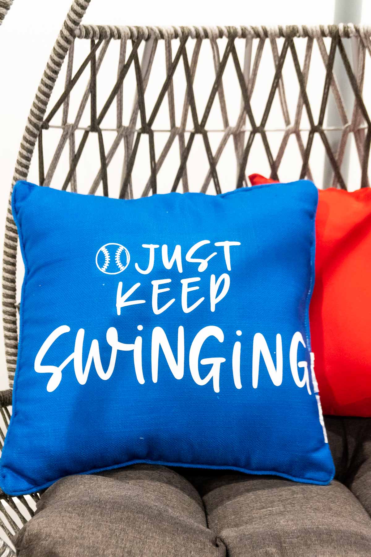 blue pillow that says just keep swinging