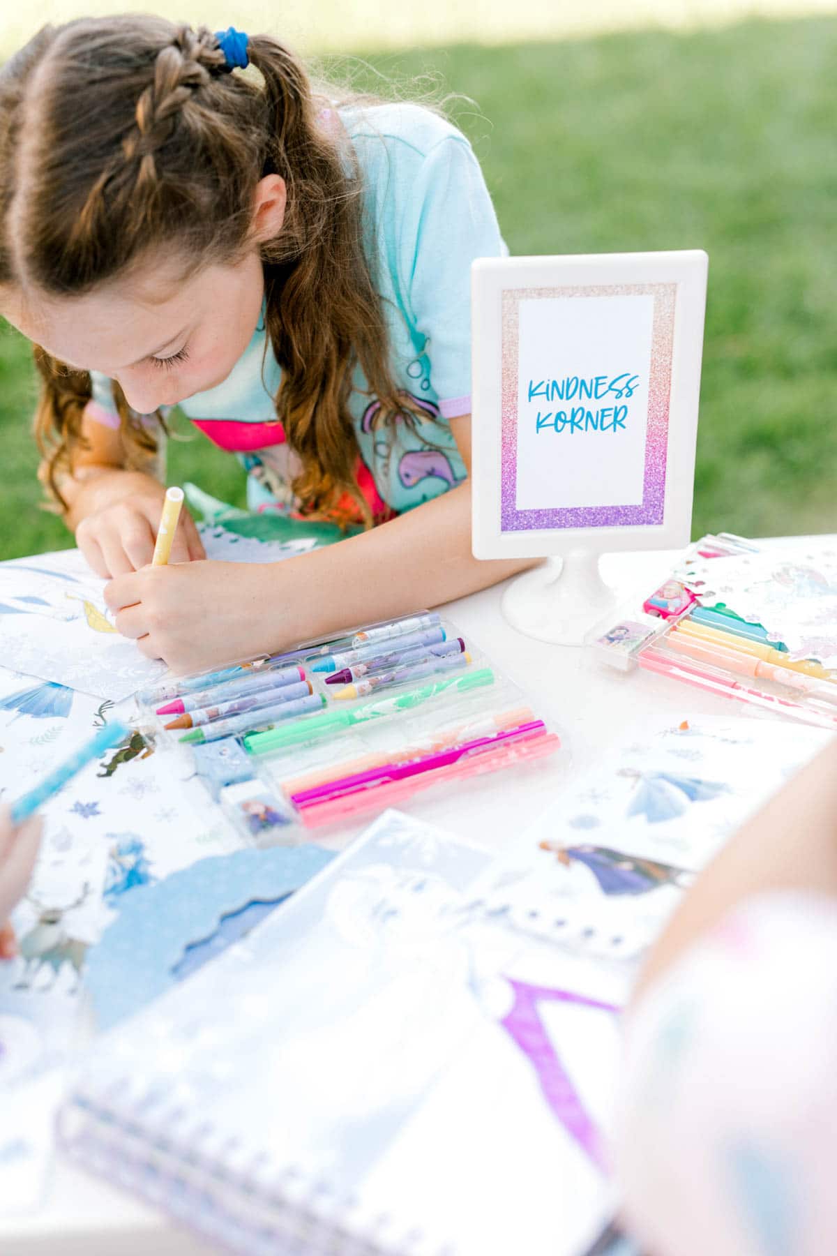 girl sitting at a table coloring