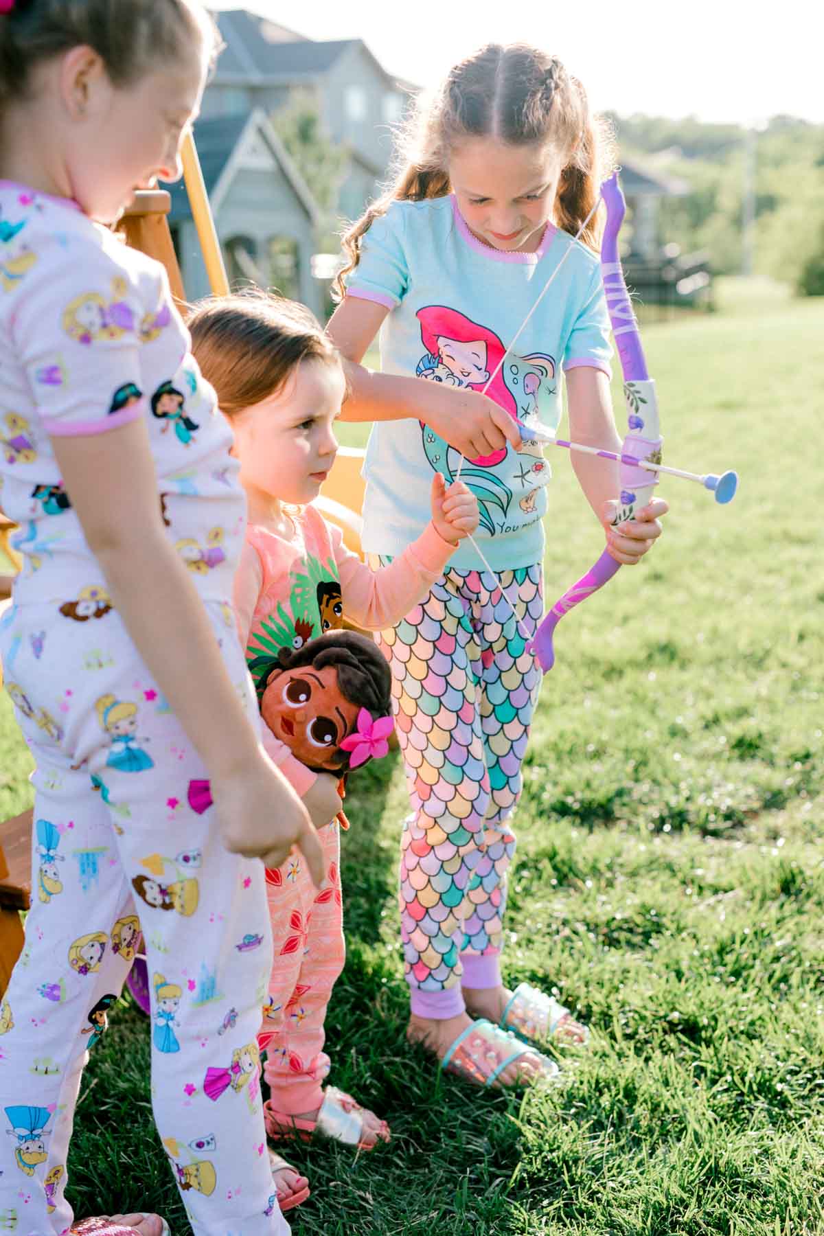 three girls holding a princess arrow set