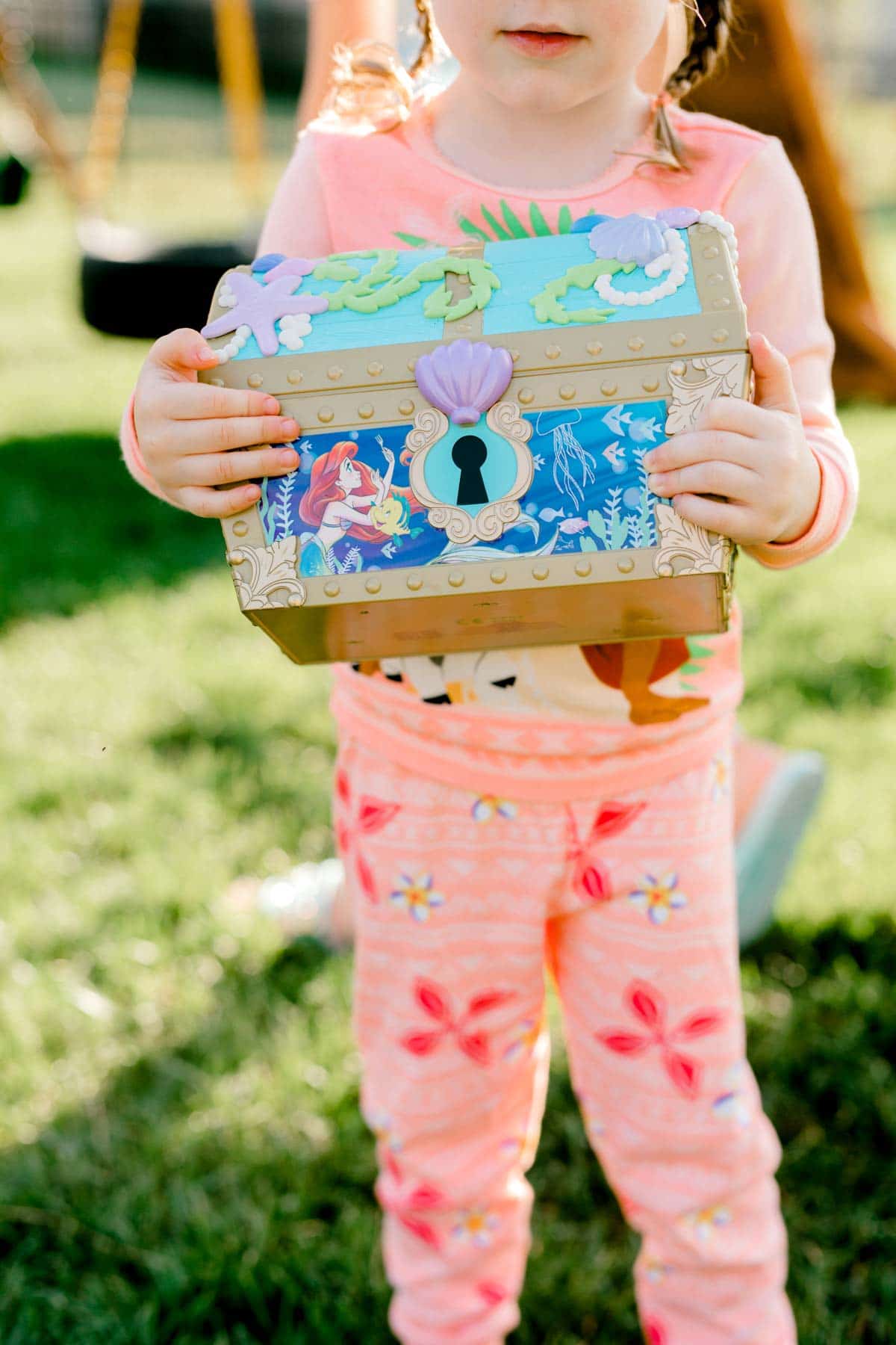 girl holding an Ariel treasure chest