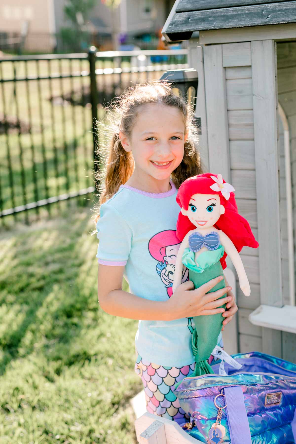 girl holding an Ariel plush