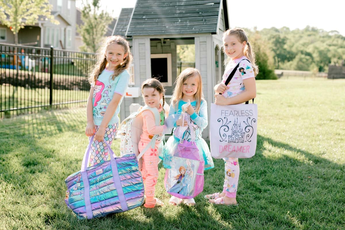 four girls holding princess bags