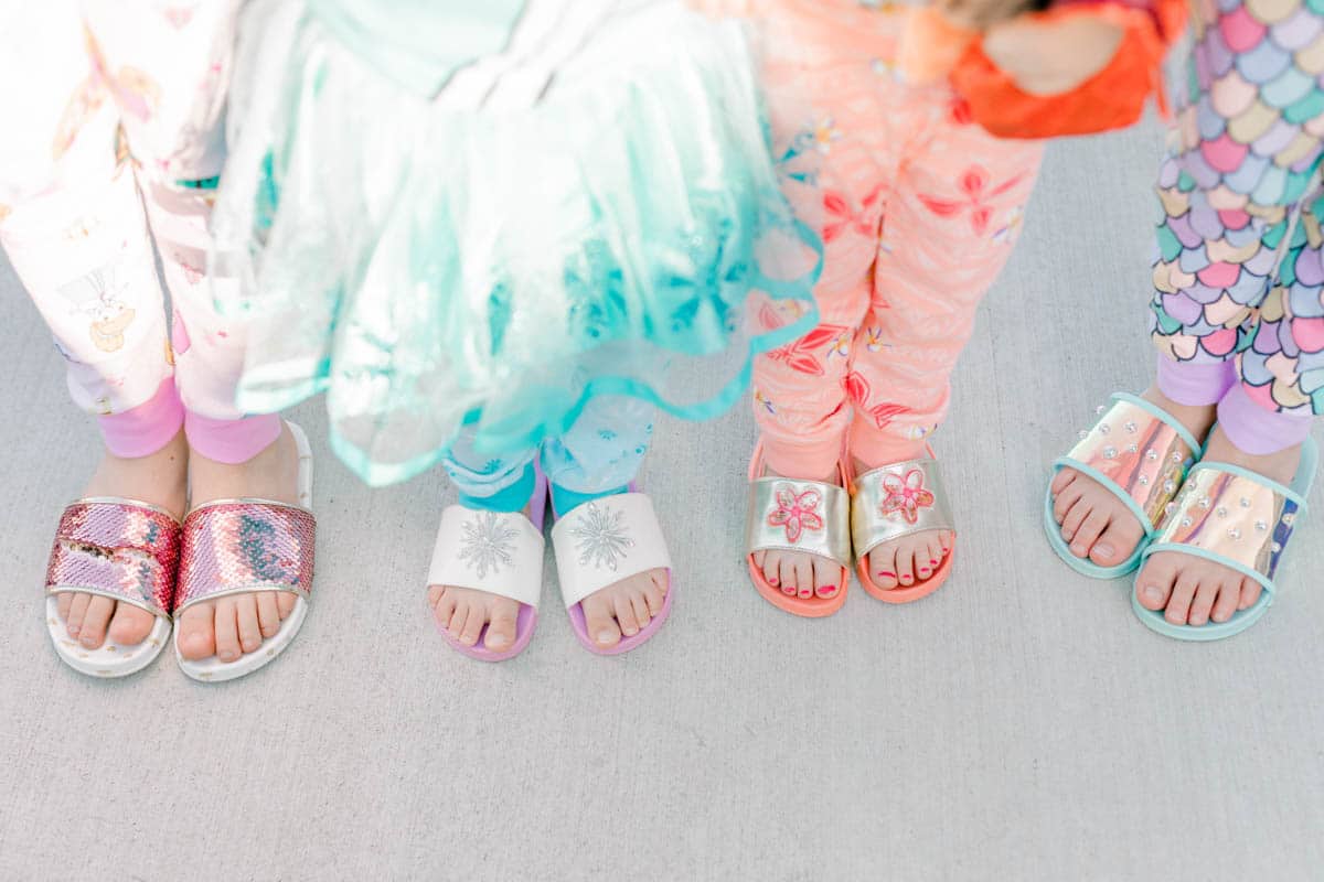 four girls wearing princess slippers