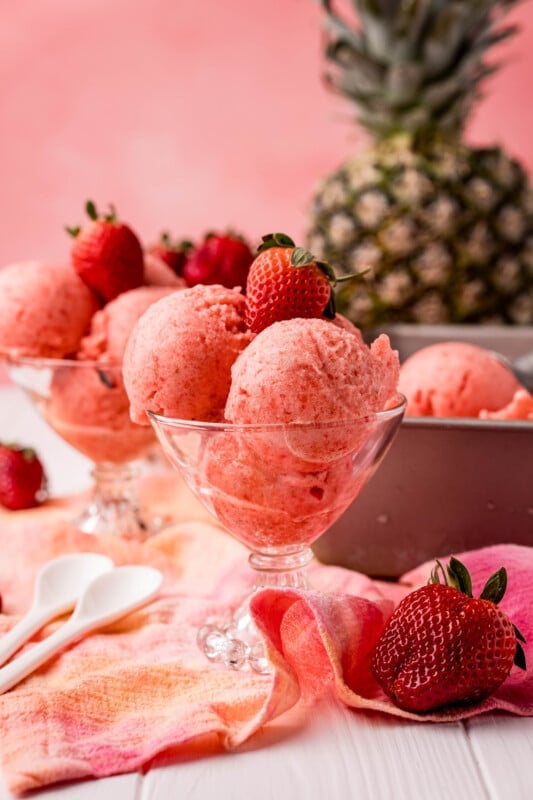Glass of strawberry pineapple sorbet with a pink background
