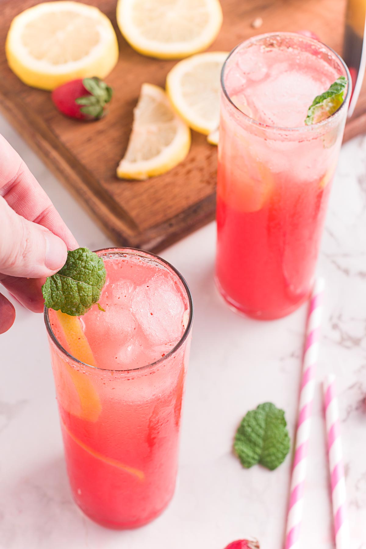 adding a piece of mint to a strawberry lemonade