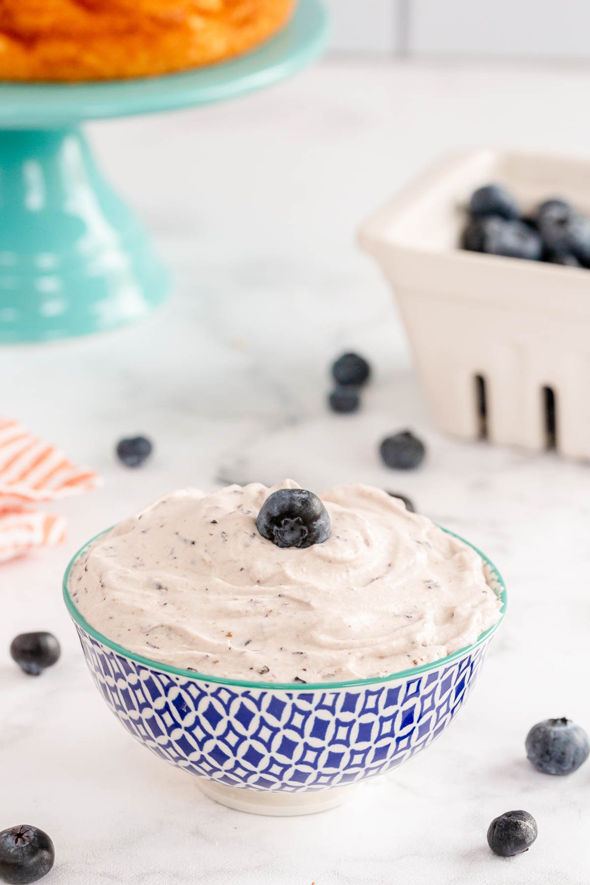 Bowl of blueberry whipped cream with a blueberry on top