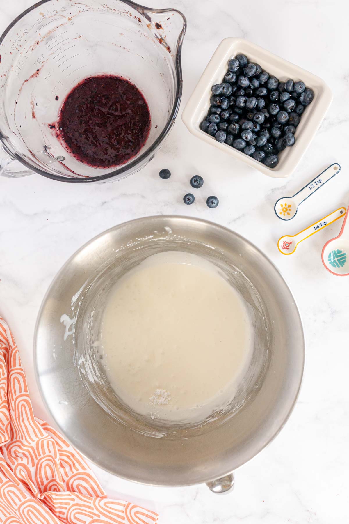 the beginnings of blueberry whipped cream in a bowl