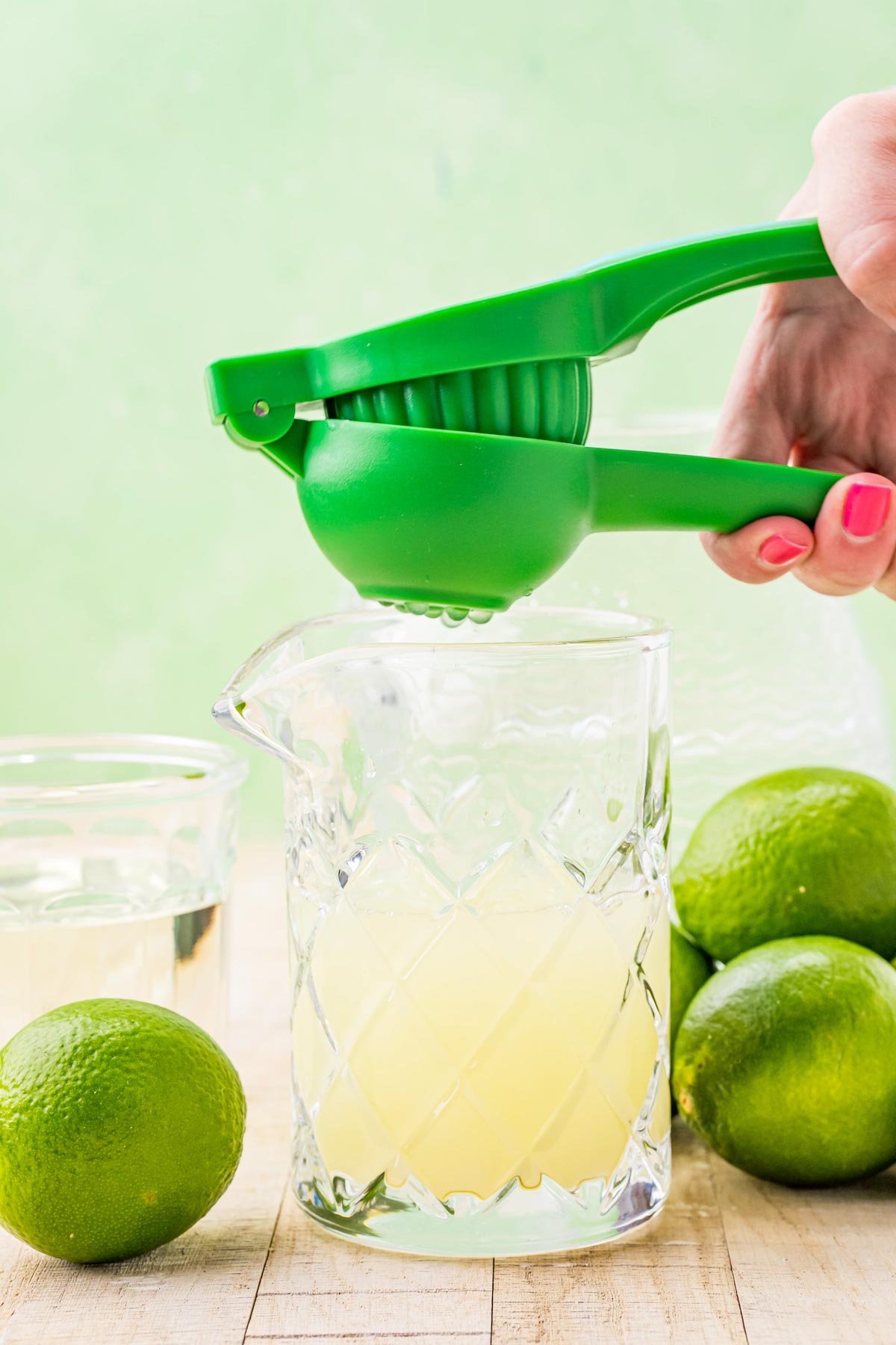 squeezing limes into a glass