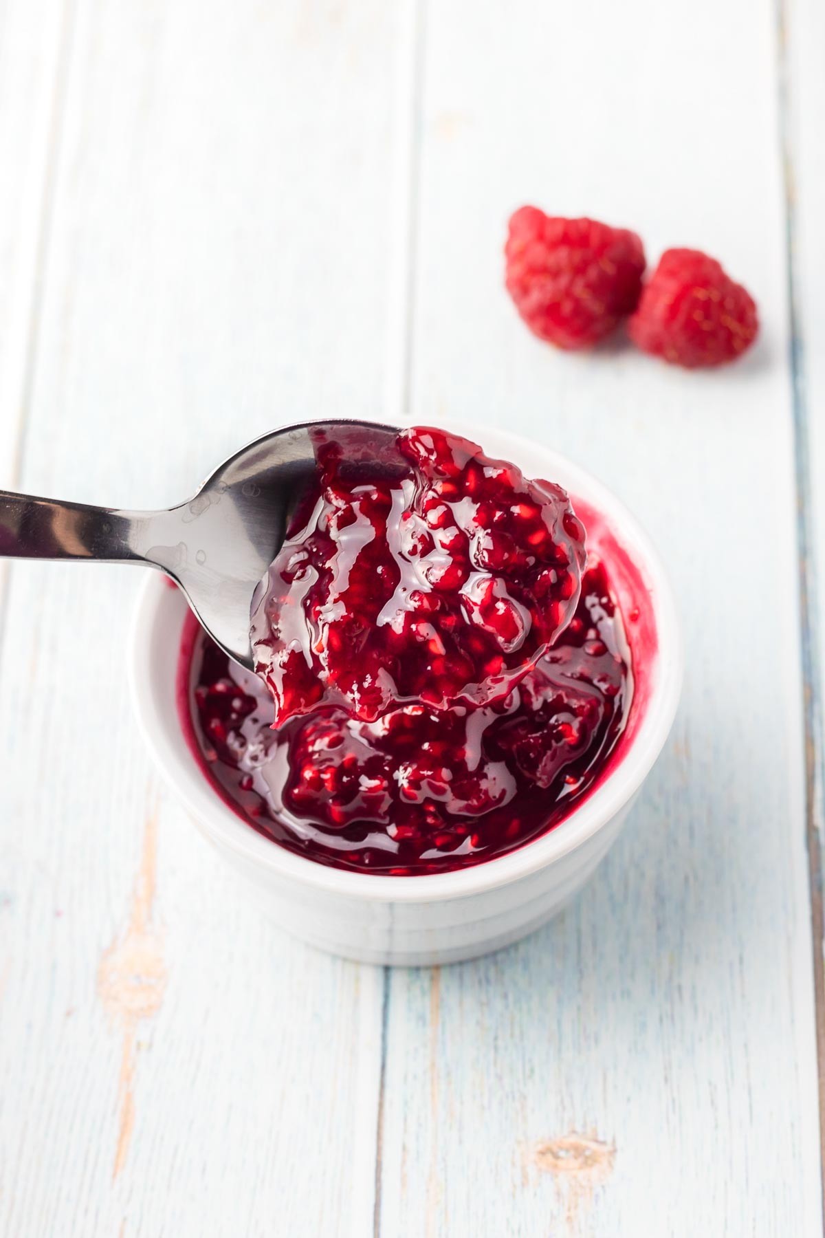 spoon in a bowl of homemade raspberry sauce